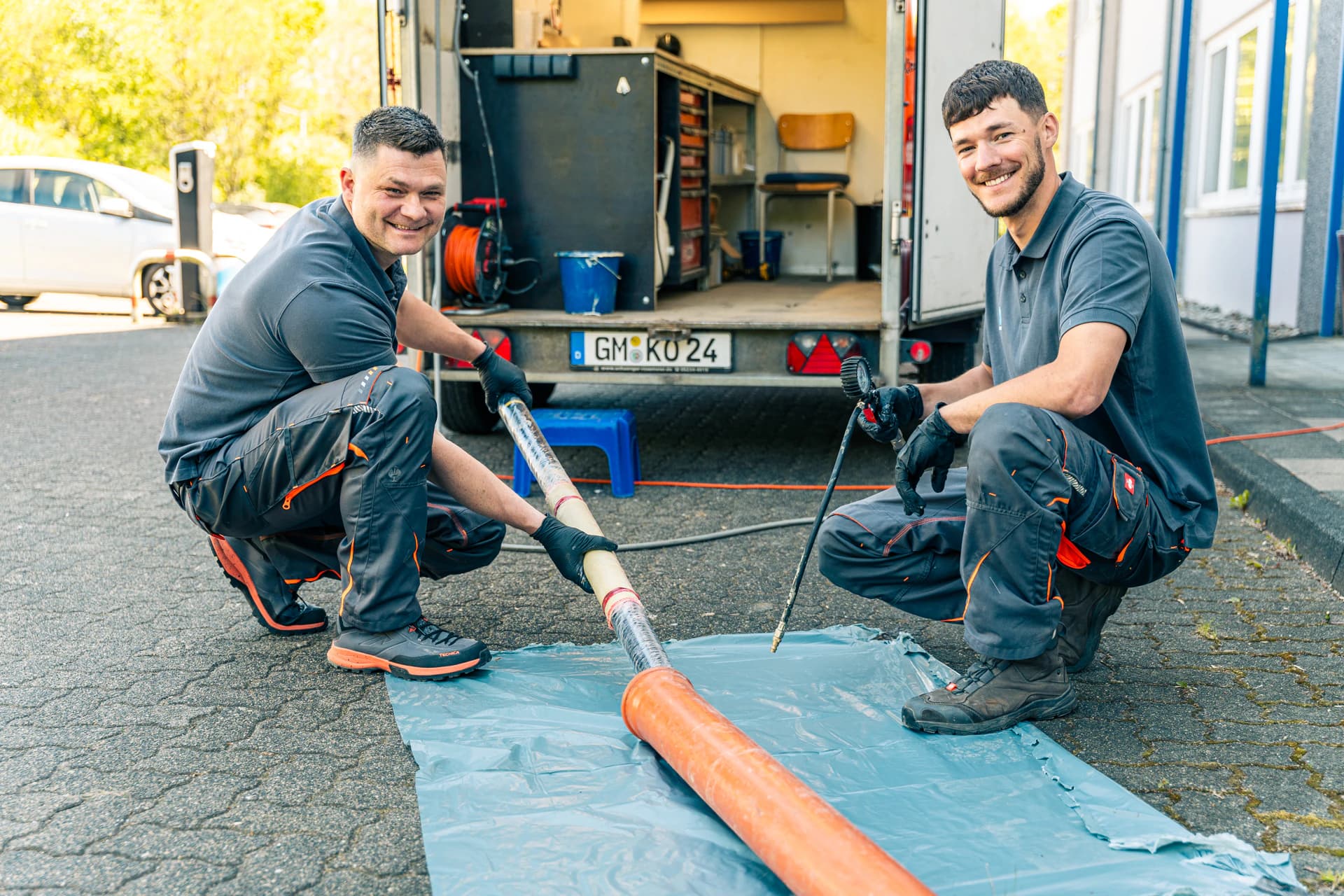 Vorbereitung eines Schlauchliners auf der Folie neben dem Werkstattanhänger